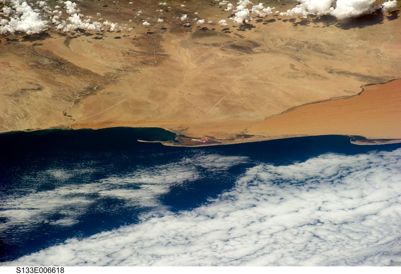 S133-E-006618 (26 Feb. 2011) --- An oblique view of Walvis Bay, Namibia, in the South Atlantic Ocean,  was provided by an STS-133 crew member onboard Discovery using a digital still camera.  Approximate center coordinates of the area pictured are 23.0 degrees south latitude and 14.5 degrees east longitude. Seen also are parts of the  Namibian Desert, Pelican Point (sand spit), and Kuiseb River on the edge of the dune field.  Photo credit: NASA or National Aeronautics and Space Administration