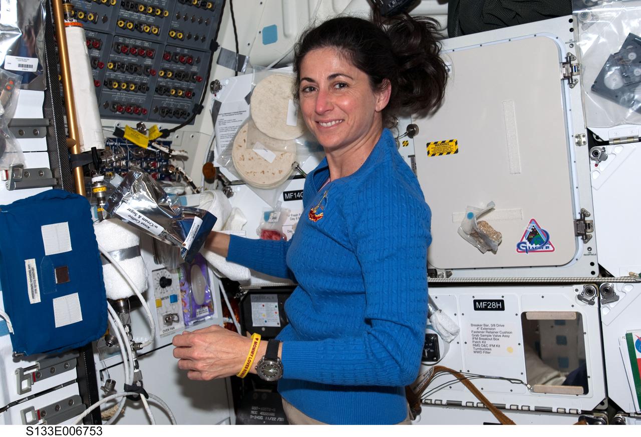 S133-E-006753 (26 Feb. 2011) --- NASA astronaut Nicole Stott, STS-133 mission specialist, prepares a beverage at the gallery on the middeck of space shuttle Discovery during flight day three activities. Photo credit: NASA or National Aeronautics and Space Administration