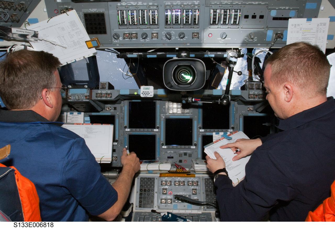 S133-E-006818 (26 Feb. 2011) --- NASA astronauts Steve Lindsey (left), STS-133 commander; and Eric Boe, pilot, occupy their respective stations on the flight deck of space shuttle Discovery during flight day three activities. Photo credit: NASA or National Aeronautics and Space Administration