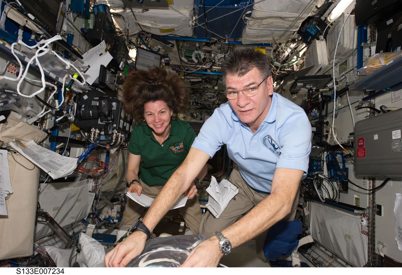 S133-E-007234 (27 Feb. 2011) --- European Space Agency astronaut Paolo Nespoli and NASA astronaut Cady Coleman, both Expedition 26 flight engineers, work in the Destiny laboratory of the International Space Station while space shuttle Discovery (STS-133) remains docked with the station. Photo credit: NASA or National Aeronautics and Space Administration