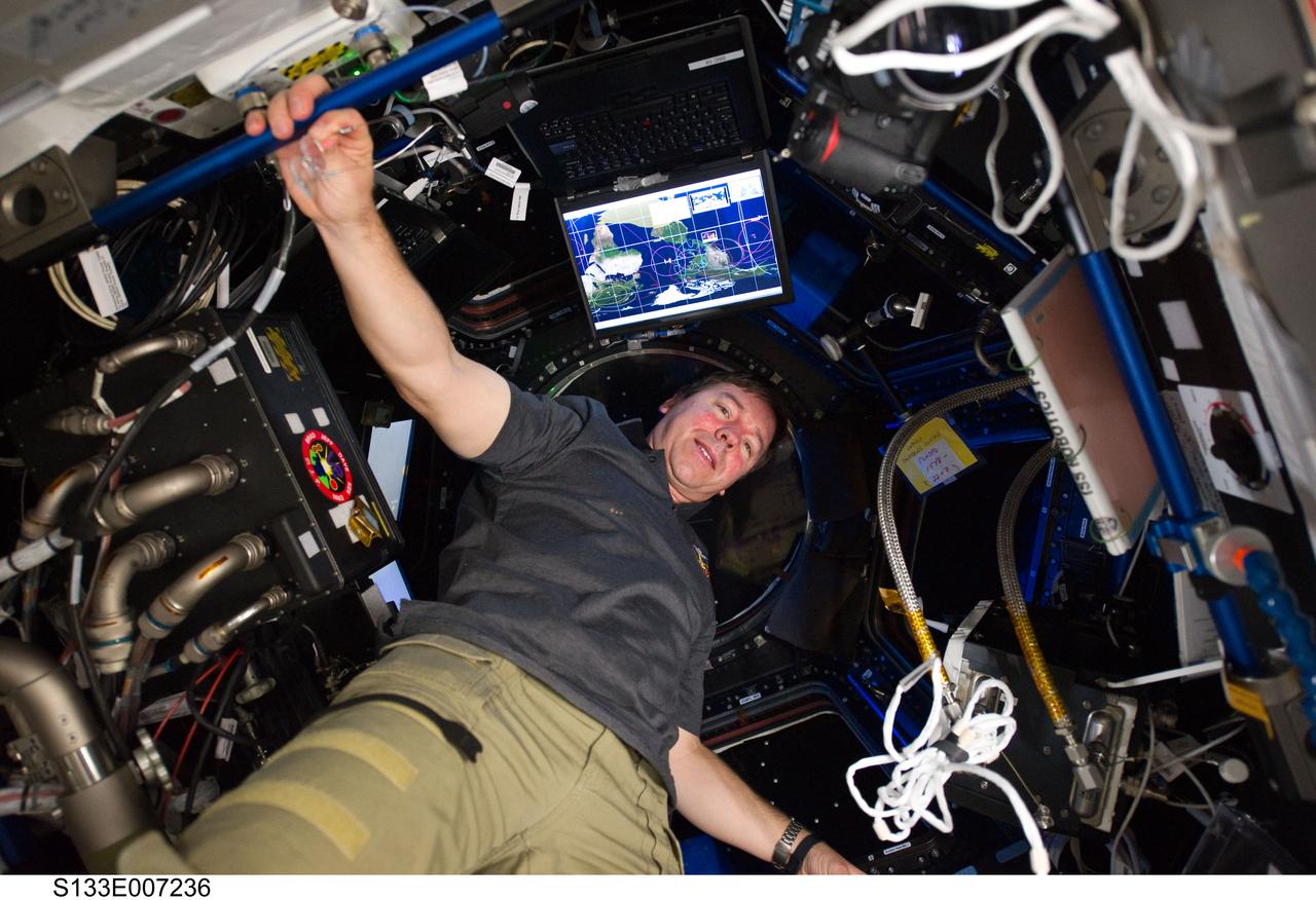 S133-E-007236 (27 Feb. 2011) --- NASA astronaut Michael Barratt, STS-133 mission specialist, is pictured in the Cupola of the International Space Station while space shuttle Discovery remains docked with the station. Photo credit: NASA or National Aeronautics and Space Administration