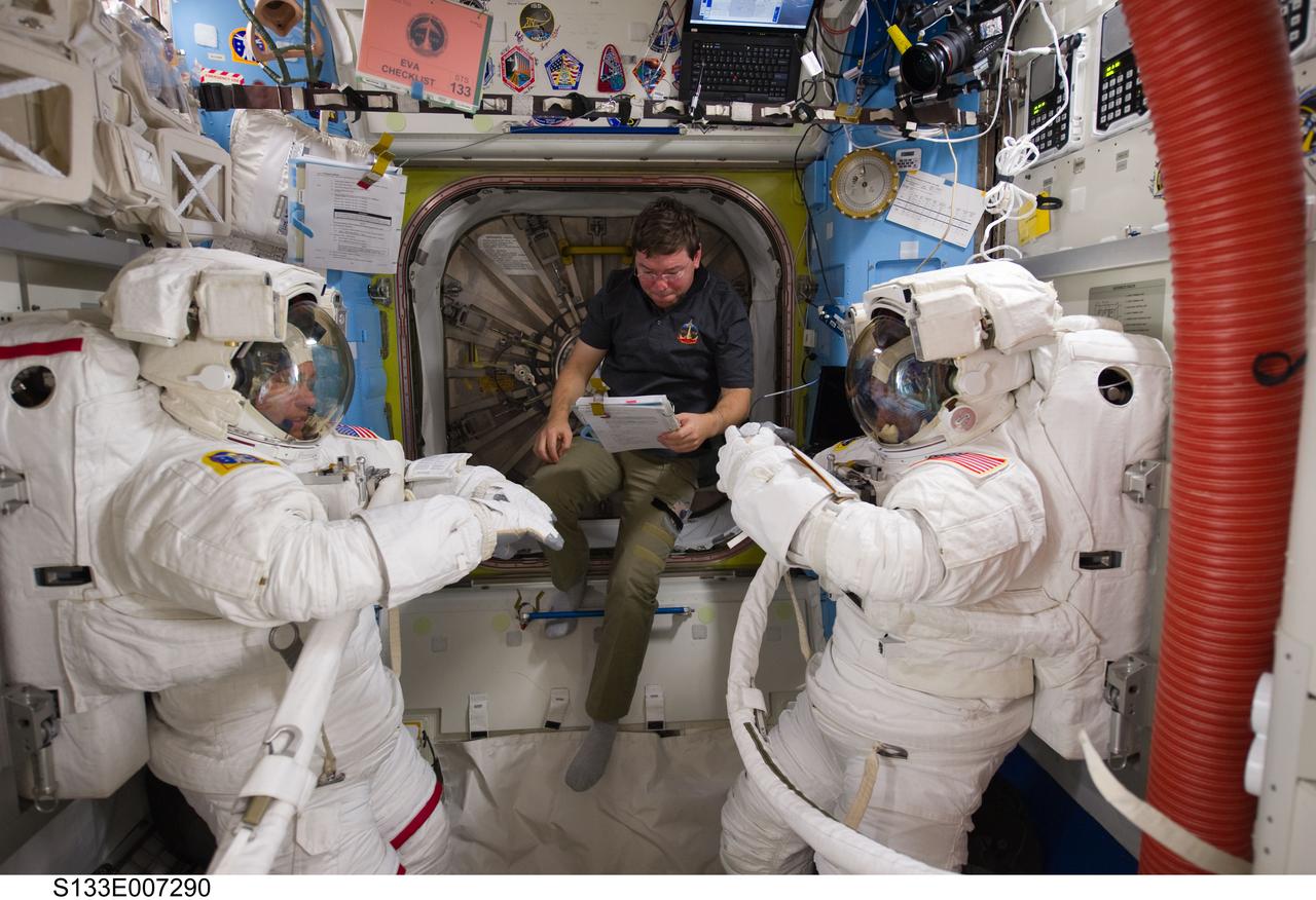 S133-E-007290 (28 Feb. 2011) --- NASA astronauts Steve Bowen (left), Michael Barratt (center) and Alvin Drew, all STS-133 mission specialists, are pictured in the Quest airlock of the International Space Station as they prepare for the start of the mission's first spacewalk. Bowen and Drew are wearing Extravehicular Mobility Unit (EMU) spacesuits. Photo credit: NASA or National Aeronautics and Space Administration
