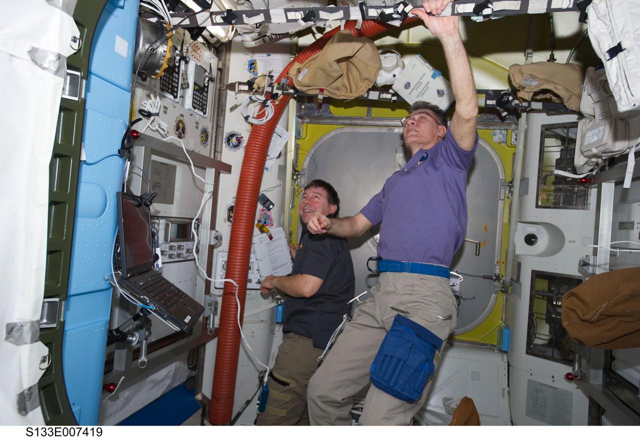 S133-E-007419 (28 Feb. 2011) --- European Space Agency astronaut Paolo Nespoli (right), Expedition 26 flight engineer; and NASA astronaut Michael Barratt, STS-133 mission specialist, are pictured in the Quest airlock of the International Space Station while space shuttle Discovery remains docked with the station. Photo credit: NASA or National Aeronautics and Space Administration