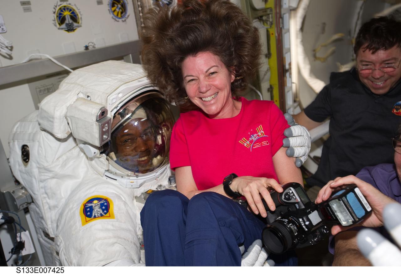S133-E-007425 (28 Feb. 2011) --- NASA astronauts Cady Coleman, Expedition 26 flight engineer, Alvin Drew and Michael Barratt (background), both STS-133 mission specialists, enjoy a light moment in the Quest airlock of the International Space Station as the mission?s first spacewalk draws to a close. Photo credit: NASA or National Aeronautics and Space Administration