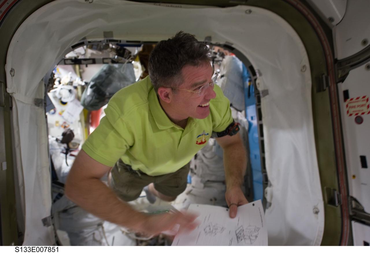 S133-E-007851 (1 March 2011) --- NASA astronaut Steve Bowen, STS-133 mission specialist, floats through a hatch on the International Space Station while space shuttle Discovery remains docked with the station. Photo credit: NASA or National Aeronautics and Space Administration