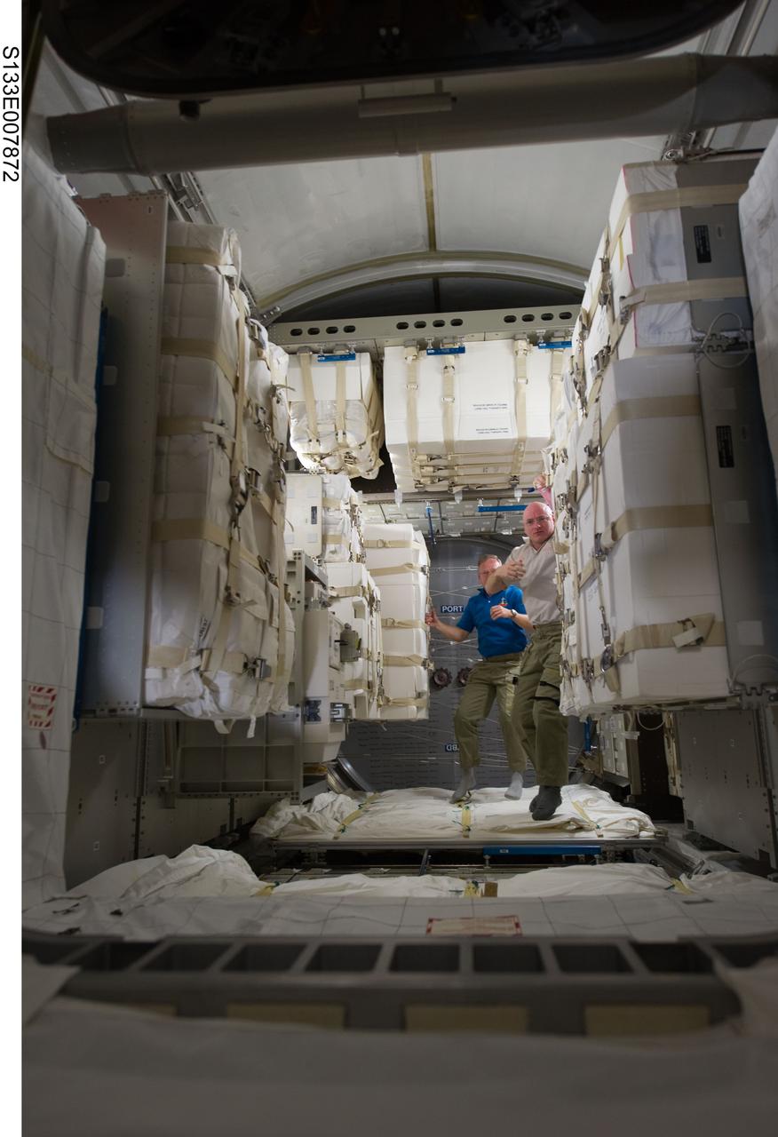 S133-E-007872 (1 March 2011) --- NASA astronauts Scott Kelly (foreground), Expedition 26 commander; and Steve Lindsey, STS-133 commander, are pictured in the newly-installed Permanent Multipurpose Module (PMM) of the International Space Station while space shuttle Discovery remains docked with the station. Photo credit: NASA or National Aeronautics and Space Administration