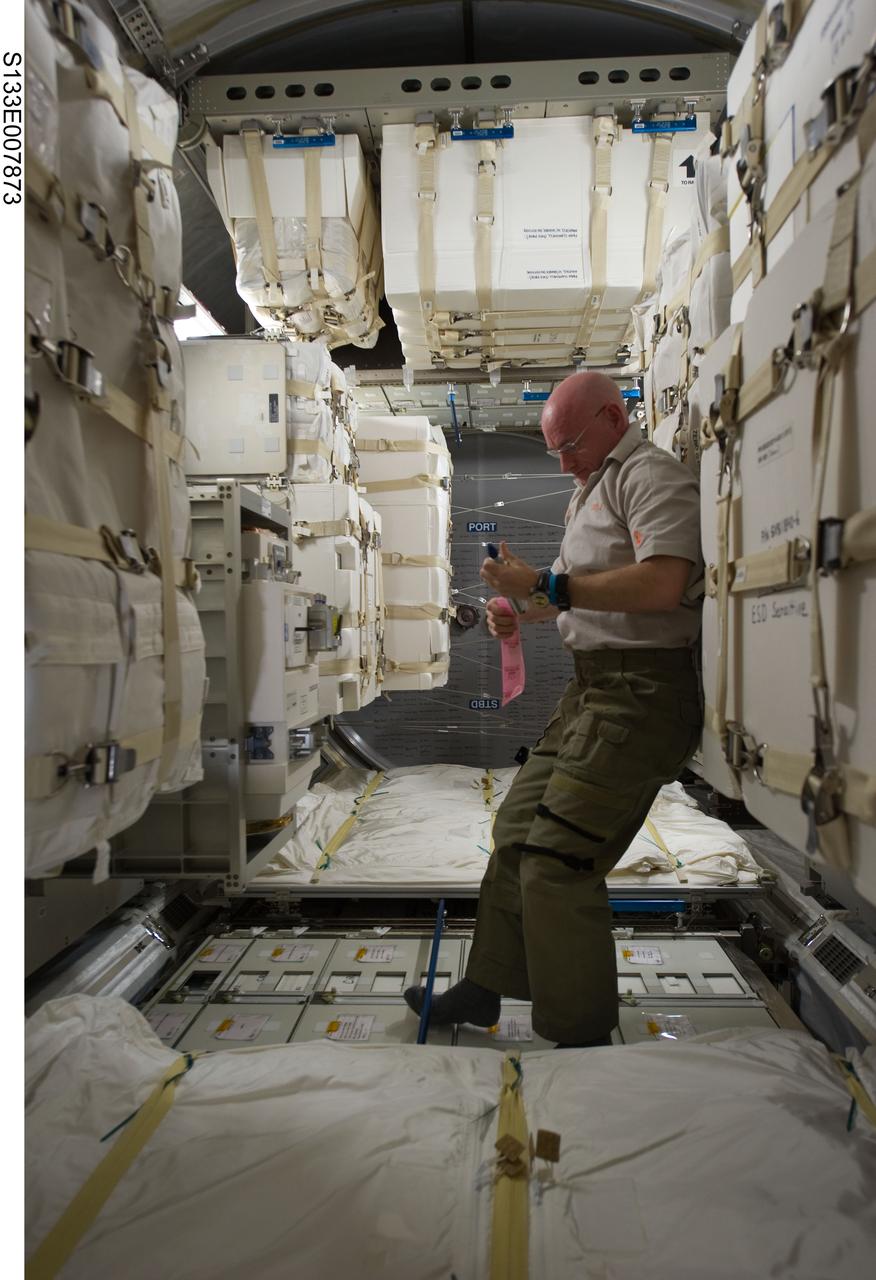 S133-E-007873 (1 March 2011) --- NASA astronaut Scott Kelly, Expedition 26 commander, is pictured in the newly-installed Permanent Multipurpose Module (PMM) of the International Space Station while space shuttle Discovery (STS-133) remains docked with the station. Photo credit: NASA or National Aeronautics and Space Administration