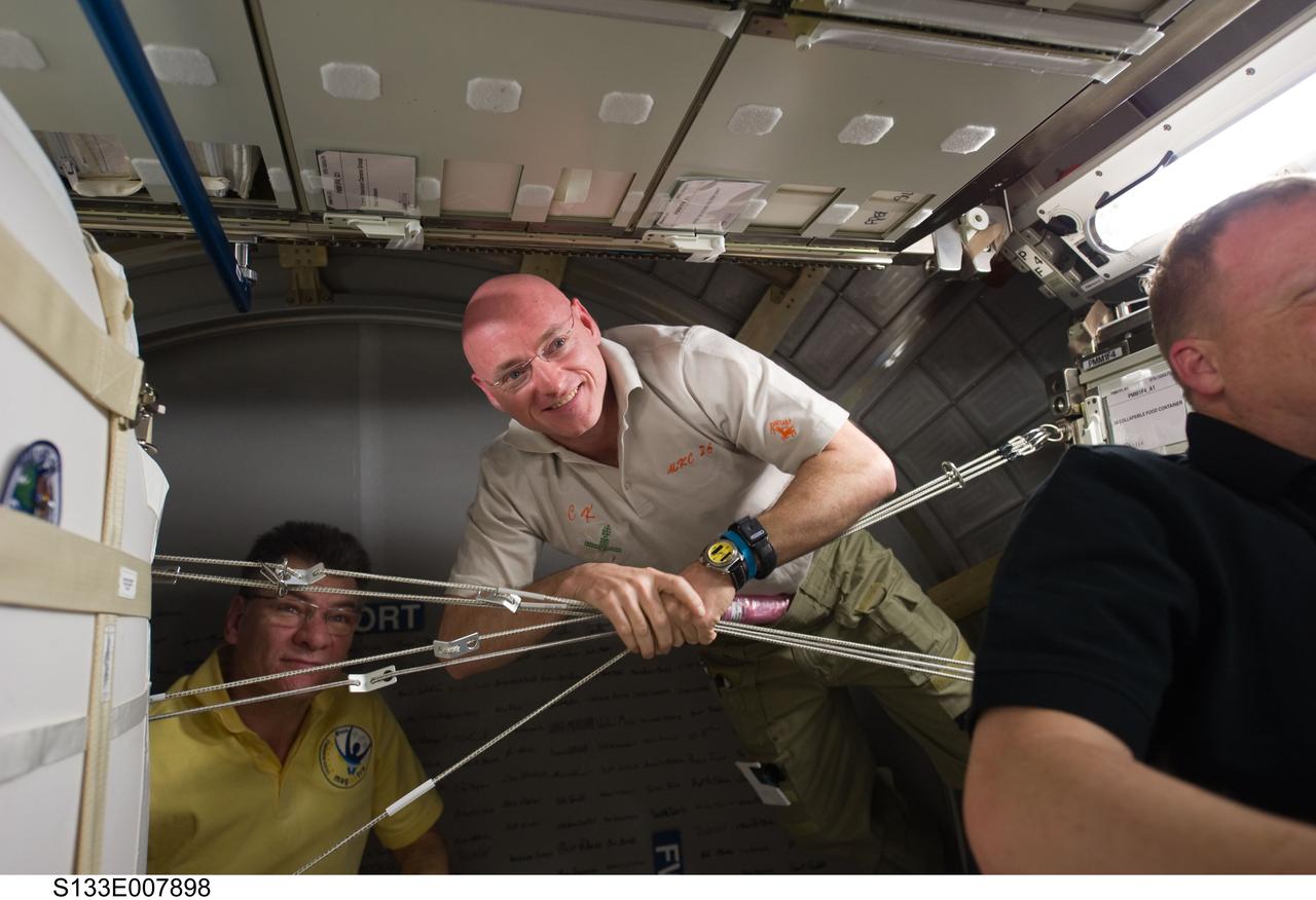 S133-E-007898 (1 March 2011) --- NASA astronauts Scott Kelly (center), Expedition 26 commander; and Eric Boe (right), STS-133 pilot; along with European Space Agency astronaut Paolo Nespoli, Expedition 26 flight engineer, are pictured in the newly-installed Permanent Multipurpose Module (PMM) of the International Space Station while space shuttle Discovery remains docked with the station. Photo credit: NASA or National Aeronautics and Space Administration