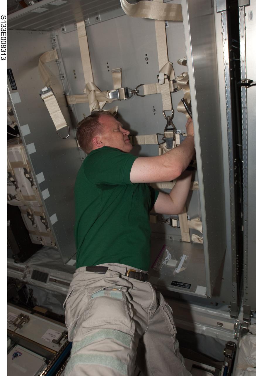 S133-E-008313 (2 March 2011) --- NASA astronaut Eric Boe, STS-133 pilot, works in the newly-installed Permanent Multipurpose Module (PMM) of the International Space Station while space shuttle Discovery remains docked with the station. Photo credit: NASA or National Aeronautics and Space Administration