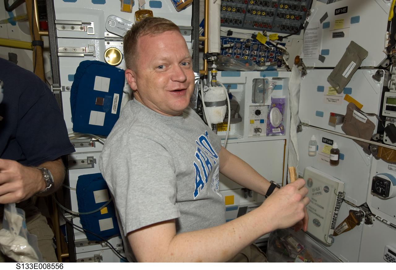 S133-E-008556 (4 March 2011) --- Astronaut Eric Boe, STS-133 pilot, grabs a snack on the middeck of space shuttle Discovery, currently docked to the International Space Station. An aggregate of 12 astronauts and Russian cosmonauts are working on the orbital outpost to mostly accomplish moving and packing of supplies and hardware. Photo credit: National Aeronautics and Space Administration