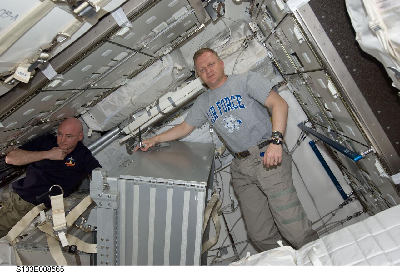 S133-E-008565 (4 March 2011) --- It's another moving day onboard the International Space Station, as NASA astronauts Scott Kelly, left, Expedition 26 commander, and Eric Boe, STS-133/Discovery pilot, join in the team effort of 12 total astronauts and cosmonauts working together temporarily onboard the orbital outpost. The joint crews added the pictured Permanent Multipurpose Module (PMM) to the station earlier in the week. Photo credit: NASA or National Aeronautics and Space Administration