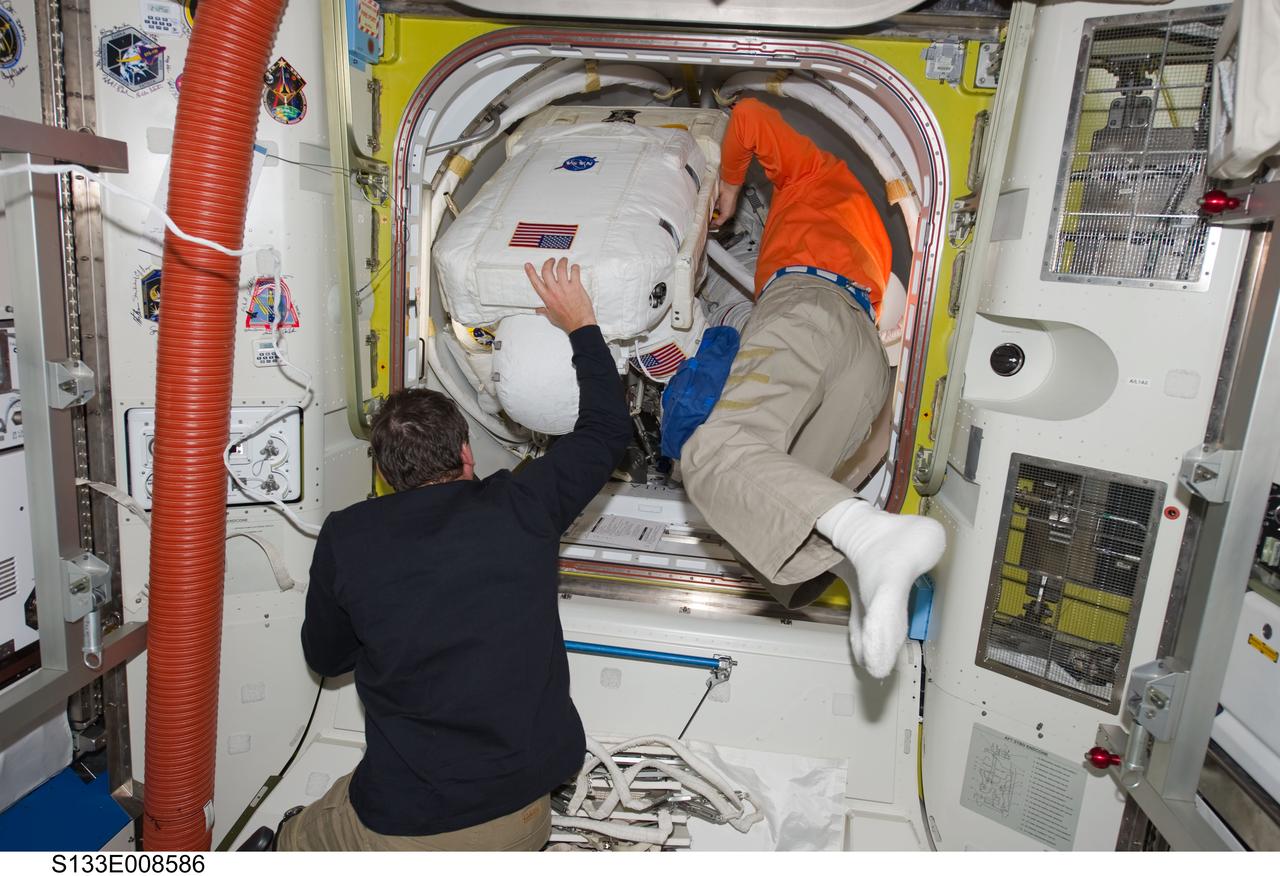 S133-E-008586 (2 March 2011) --- Attired in his Extravehicular Mobility Unit (EMU) spacesuit, NASA astronaut Alvin Drew, STS-133 mission specialist, enters the International Space Station's Quest airlock as the mission's second spacewalk draws to a close. NASA astronaut Michael Barratt (left), STS-133 mission specialist; and European Space Agency astronaut Paolo Nespoli, Expedition 26 flight engineer, assisted Drew. Photo credit: NASA or National Aeronautics and Space Administration