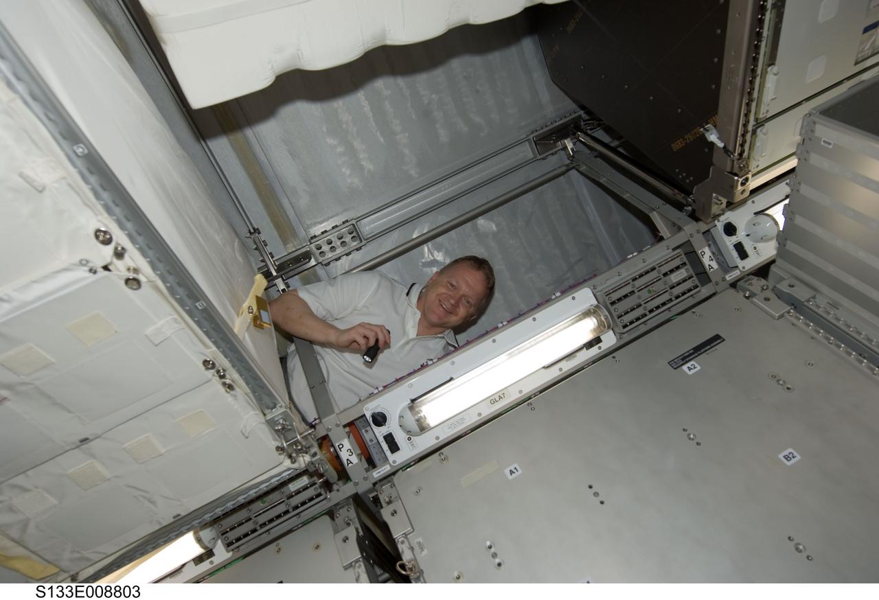 S133-E-008803 (5 March 2011) --- NASA astronaut Eric Boe, STS-133 pilot, works in the Permanent Multipurpose Module (PMM) of the International Space Station while space shuttle Discovery remains docked with the station. Photo credit: NASA or National Aeronautics and Space Administration