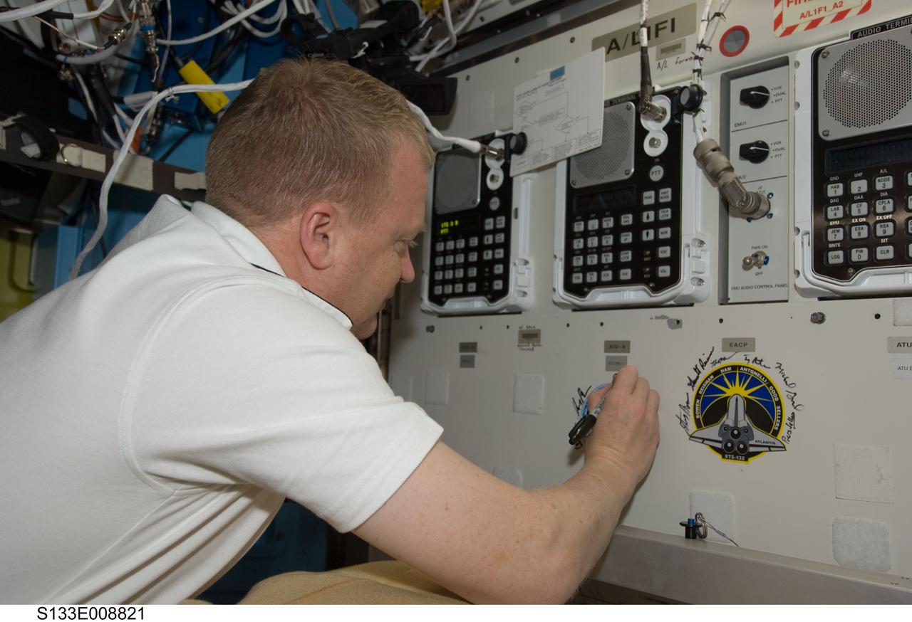 S133-E-008821 (5 March 2011) --- NASA astronaut Eric Boe, STS-133 pilot, signs the STS-133 patch, which was added to the growing collection of insignias representing crews who performed spacewalks from the Quest airlock of the International Space Station. Photo credit: NASA or National Aeronautics and Space Administration