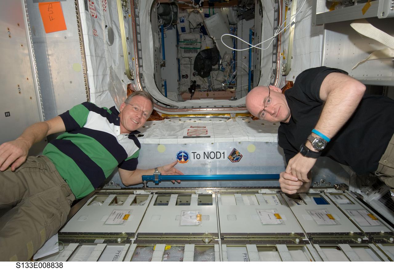 S133-E-008838 (5 March 2011) --- NASA astronauts Steve Lindsey (left), STS-133 commander; and Scott Kelly, Expedition 26 commander, pose after placing their mission patches in the newly-installed Permanent Multipurpose Module (PMM) of the International Space Station while space shuttle Discovery remains docked with the station. Photo credit: NASA or National Aeronautics and Space Administration
