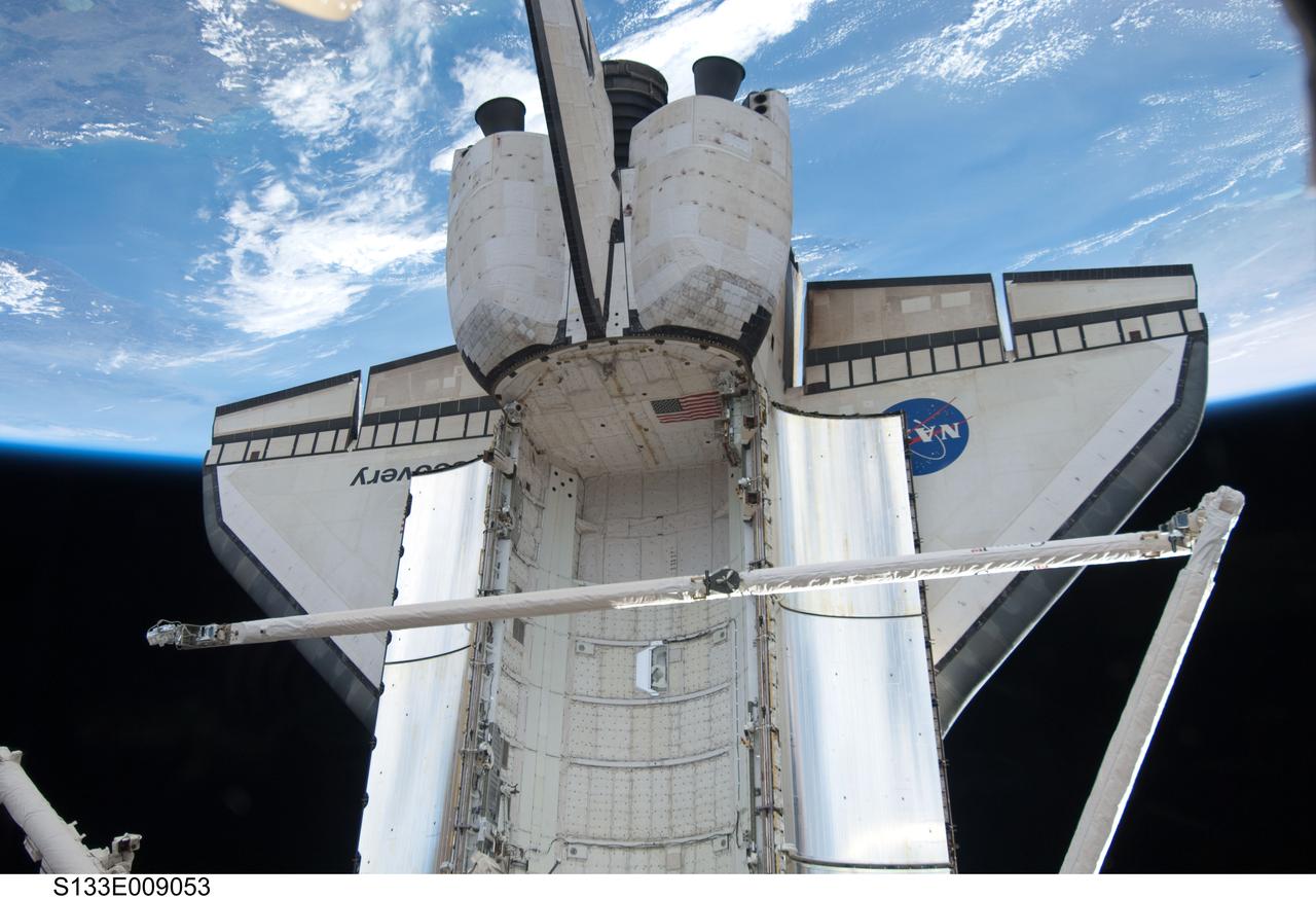 S133-E-009053 (6 March 2011) --- Backdropped by Earth’s horizon and the blackness of space, space shuttle Discovery and its remote manipulator system/orbiter boom sensor system (RMS/OBSS) is featured in this image photographed by an STS-133 crew member while docked with the International Space Station. Photo credit: NASA or National Aeronautics and Space Administration