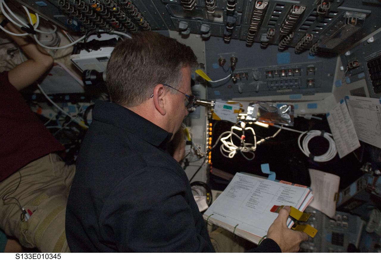 S133-E-010345 (7 March 2011) --- NASA astronaut Steve Lindsey, STS-133 commander, reads a procedures checklist on the flight deck of space shuttle Discovery during flight day 12 activities. Photo credit: NASA or National Aeronautics and Space Administration