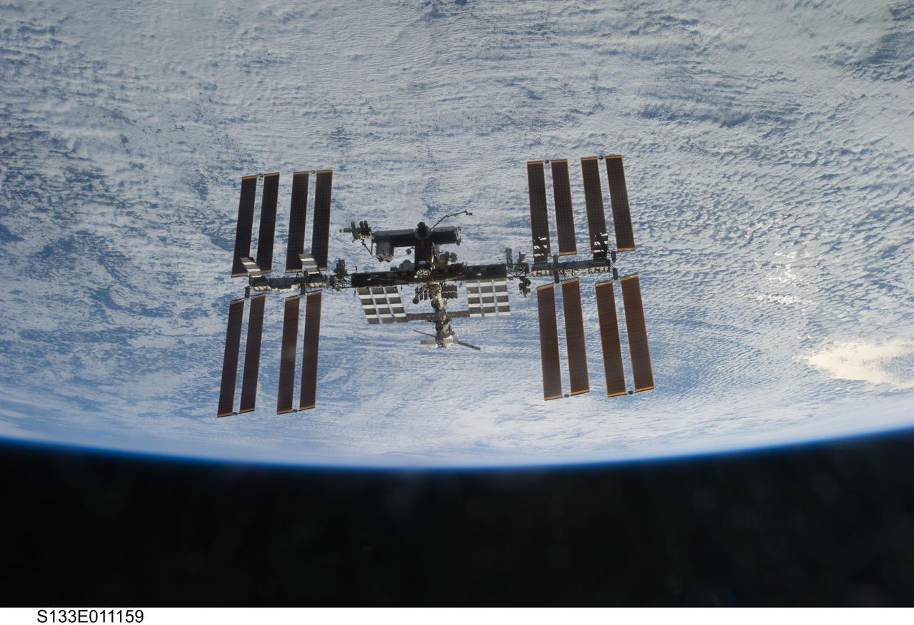 S133-E-011159 (7 March 2011) ---  Backdropped against clouds over Earth, the International Space Station is seen from Discovery as the two orbital spacecraft accomplish their relative separation on March 7 after an aggregate of 12 astronauts and cosmonauts worked together for over a week. During a post undocking fly-around, the crew members aboard the two spacecraft collected a series of photos of each other’s vehicle. Photo credit: NASA or National Aeronautics and Space Administration