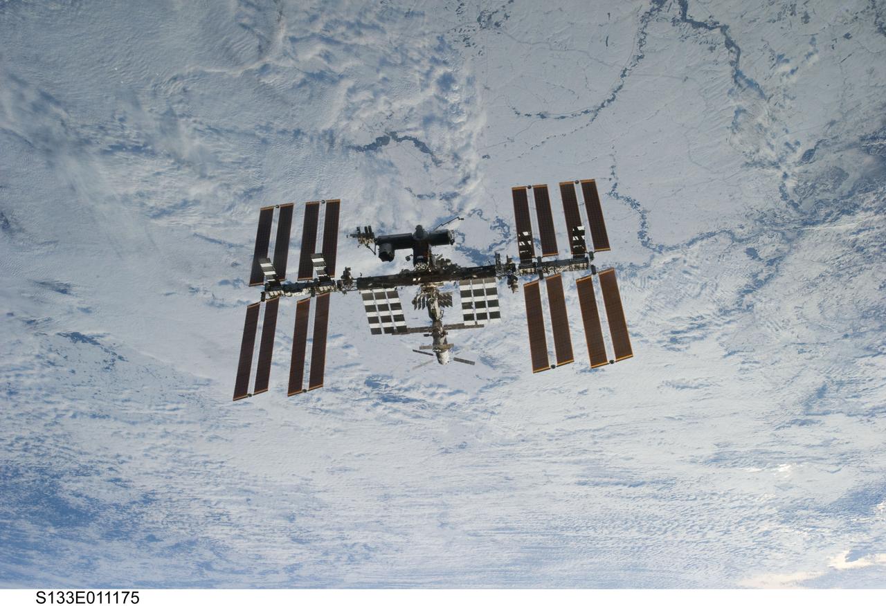 S133-E-011175 (7 March 2011) ---  Backdropped against clouds over Earth, the International Space Station is seen from Discovery as the two orbital spacecraft accomplish their relative separation on March 7 after an aggregate of 12 astronauts and cosmonauts worked together for over a week. During a post undocking fly-around, the crew members aboard the two spacecraft collected a series of photos of each other’s vehicle. Photo credit: NASA or National Aeronautics and Space Administration