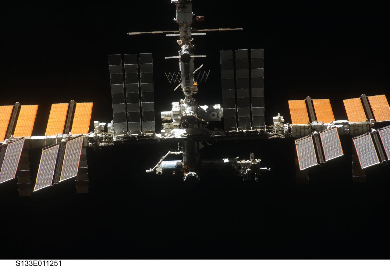 S133-E-011251 (7 March 2011) ---  Backdropped against the blackness of space, the International Space Station is seen from   Discovery as the two orbital spacecraft accomplish their relative separation on March 7 after an aggregate of 12 astronauts and cosmonauts worked together for over a week.   During a post undocking fly-around, the crew members aboard the two spacecraft collected a series of photos of each other?s vehicle. Photo credit: NASA or National Aeronautics and Space Administration