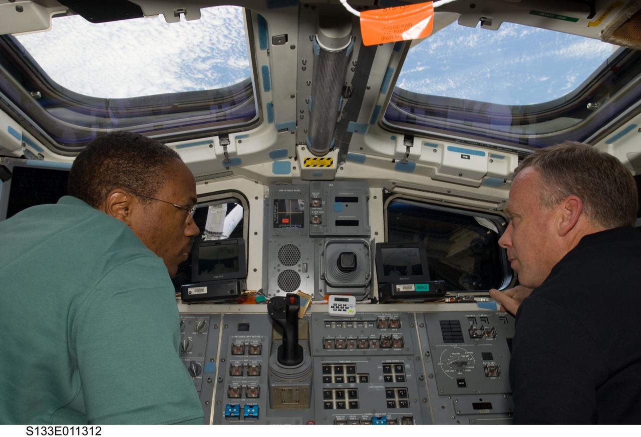 S133-E-011312 (7 March 2011) --- NASA astronauts Steve Lindsey (right), STS-133 commander; and Alvin Drew, mission specialist, are pictured on the aft flight deck of space shuttle Discovery during flight day 12 activities. Photo credit: NASA or National Aeronautics and Space Administration