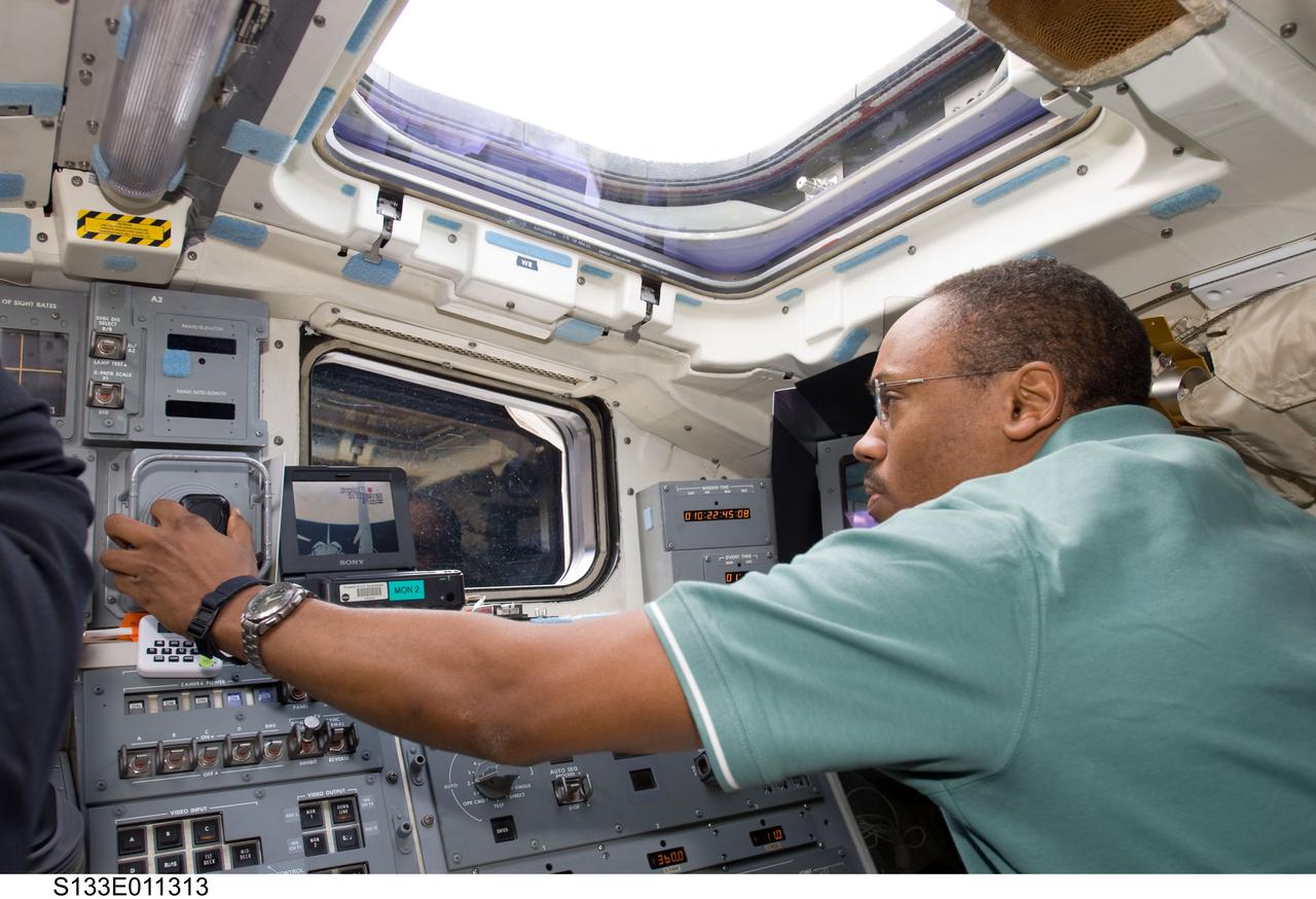 S133-E-011313 (7 March 2011) --- NASA astronaut Alvin Drew, STS-133 mission specialist, works the controls for the remote manipulator system (RMS) on the aft flight deck of space shuttle Discovery during flight day 12 activities. Photo credit: NASA or National Aeronautics and Space Administration
