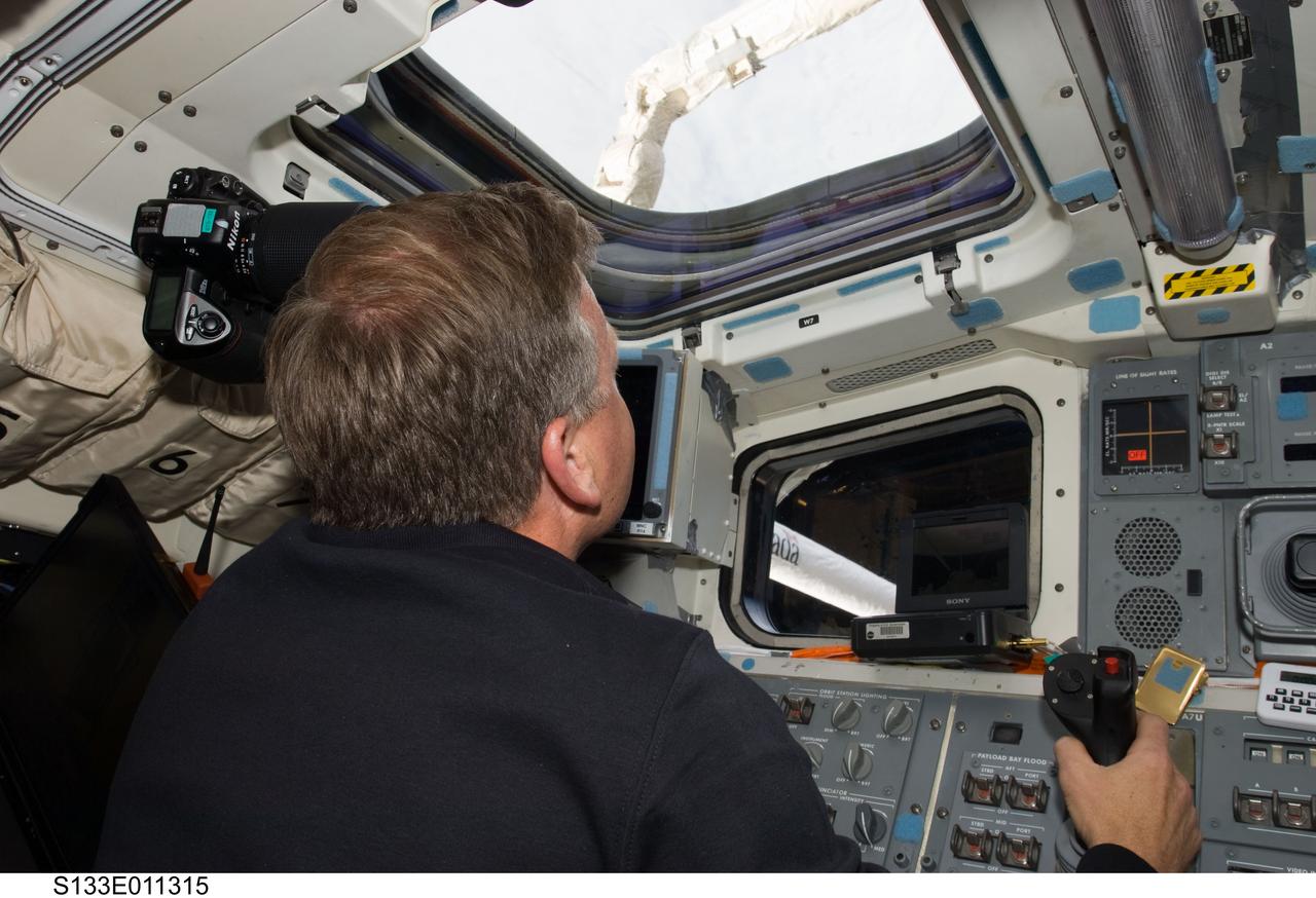 S133-E-011315 (7 March 2011) --- NASA astronaut Steve Lindsey, STS-133 commander, works the controls for the remote manipulator system (RMS) on the aft flight deck of space shuttle Discovery during flight day 12 activities. Photo credit: NASA or National Aeronautics and Space Administration