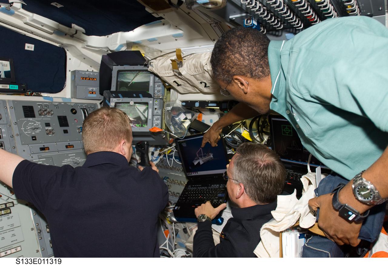 S133-E-011319 (7 March 2011) --- NASA astronauts Steve Lindsey (center), STS-133 commander; Eric Boe (left), pilot; and Alvin Drew, mission specialist, work on the aft flight deck of space shuttle Discovery during flight day 12 activities. Photo credit: NASA or National Aeronautics and Space Administration