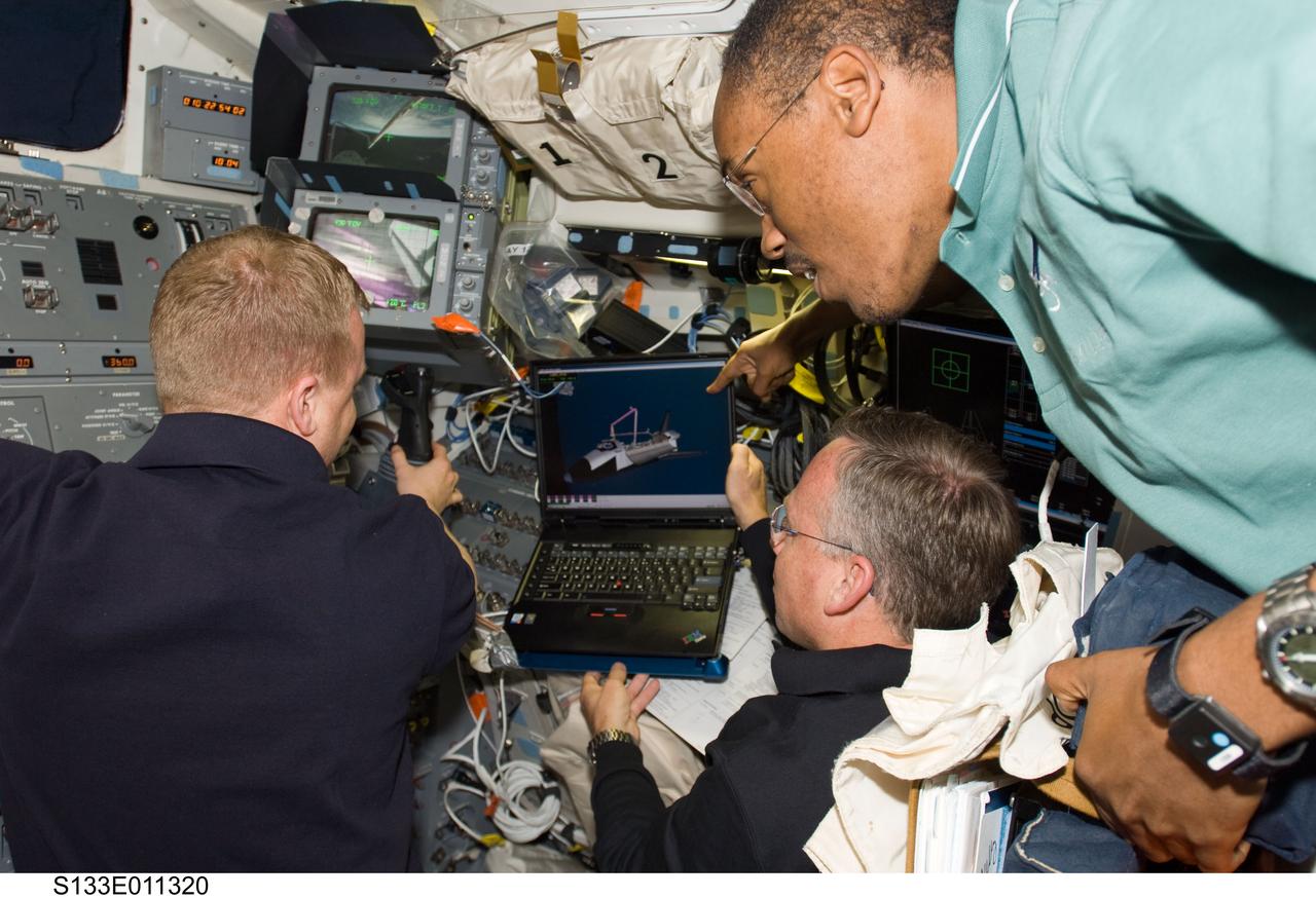 S133-E-011320 (7 March 2011) --- NASA astronauts Steve Lindsey (center), STS-133 commander; Eric Boe (left), pilot; and Alvin Drew, mission specialist, work on the aft flight deck of space shuttle Discovery during flight day 12 activities. Photo credit: NASA or National Aeronautics and Space Administration