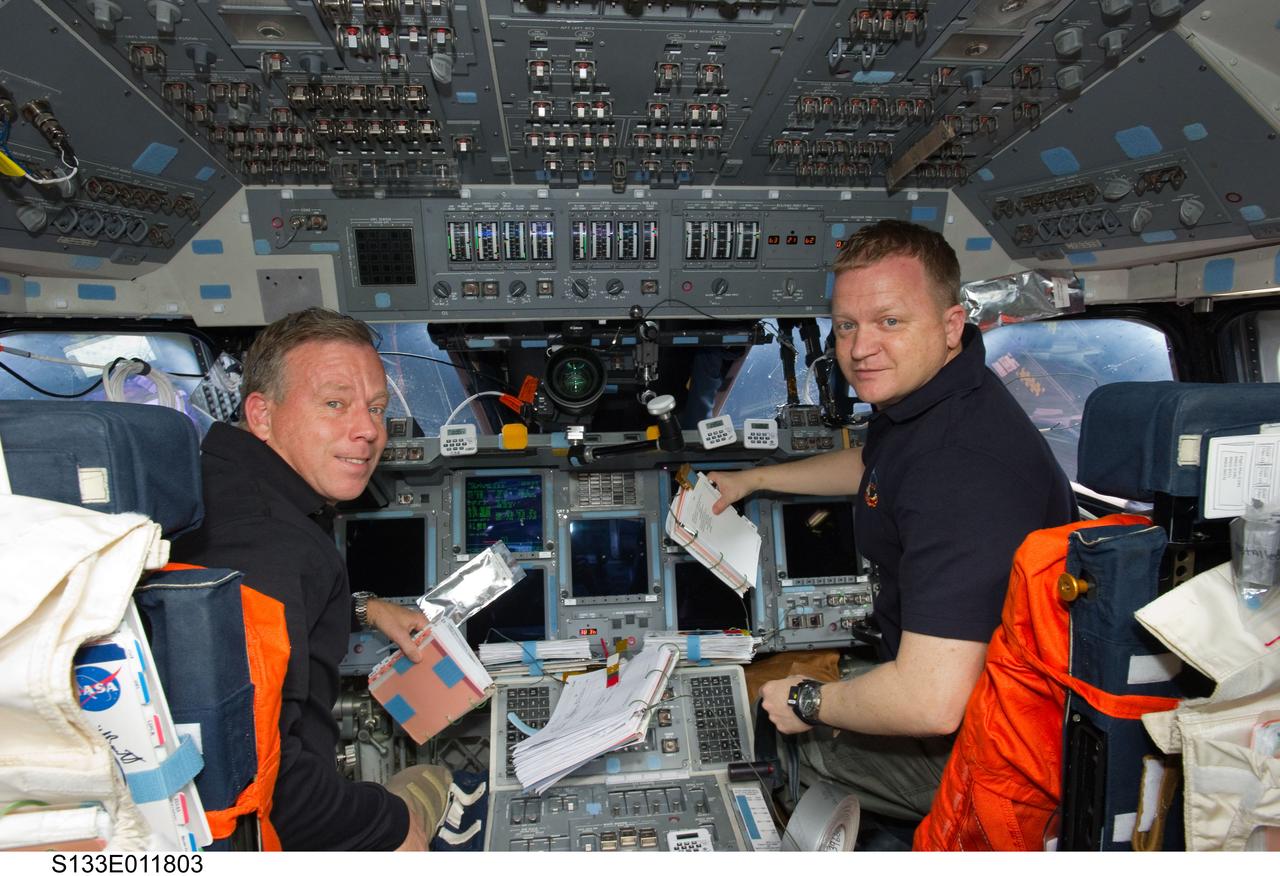 S133-E-011803 (7 March 2011) --- NASA astronauts Steve Lindsey (left), STS-133 commander; and Eric Boe, pilot, are pictured at their respective stations on the forward flight deck of space shuttle Discovery during flight day 12 activities. Photo credit: NASA or National Aeronautics and Space Administration