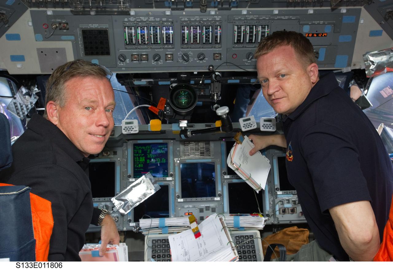 S133-E-011806 (7 March 2011) --- NASA astronauts Steve Lindsey (left), STS-133 commander; and Eric Boe, pilot, are pictured at their respective stations on the forward flight deck of space shuttle Discovery during flight day 12 activities. Photo credit: NASA or National Aeronautics and Space Administration