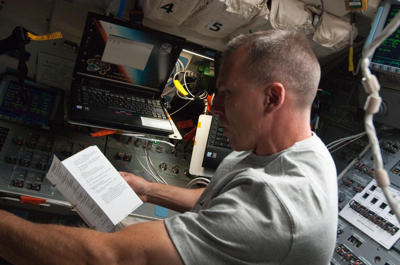 S134-E-005334 (16 May 2011) --- Astronaut Andrew Feustel, STS-134 mission specialist, looks over a crew procedures manual on the aft flight deck during the crew's first day in space, May 16, 2011. Feustel and five crewmates are destined for the International Space Station to continue work on the orbital complex. Photo credit: NASA