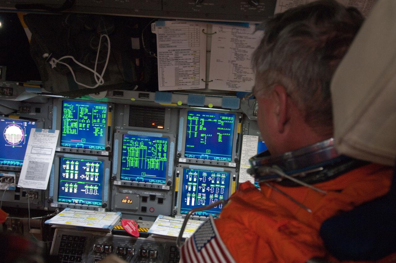 S134-E-005571 (16 May 2011) --- Astronaut Greg Johnson, STS-134 pilot, still in his orange launch and entry suit not long after the launch phase was complete, gets to work at the pilot's station on the space shuttle Endeavour's flight deck. Photo credit: NASA