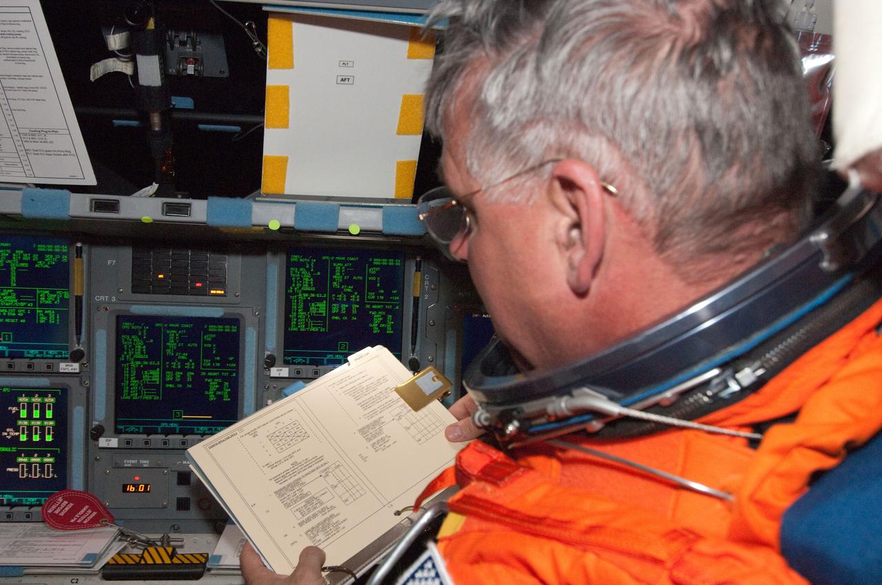 S134-E-005574 (16 May 2011) --- Astronaut Greg Johnson, STS-134 pilot, still in his orange launch and entry suit not long after the launch phase was complete, gets to work at the pilot's station on the space shuttle Endeavour's flight deck. Photo credit: NASA