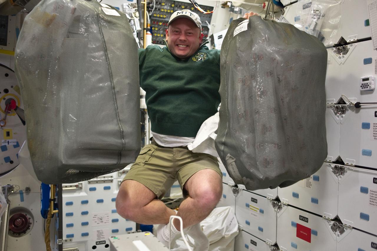 S134-E-006395 (17 May 2011) --- Veteran NASA astronaut Michael Fincke, STS-134 mission specialist, appears delighted that, because of the weightlessness of space, he can renew doing chores which he can't do on Earth, like lifting heavy bags and floating freely at the same time.  Fincke and five other astronauts share Endeavour with a large quantity of supplies and equipment as they head toward a date with the International Space Station (ISS). Endeavour was scheduled to link with ISS in less than 24 hours from the time this picture was recorded.  Photo credit: NASA