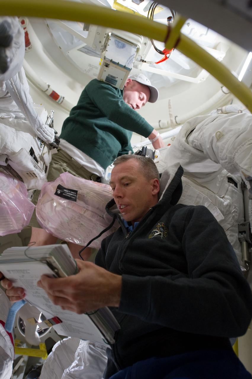 S134-E-006520 (17 May 2011) --- Astronauts Andrew Feustel (foreground) and Michael Fincke, both STS-134 mission specialists, work to keep order with the large inventory of supplies and equipment on Endeavour's middeck and airlock on the eve of docking day with the International Space Station. Photo credit: NASA.
