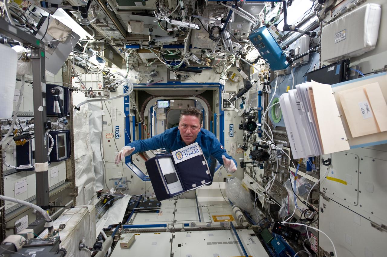 S134-E-007273 (19 May 2011) --- European Space Agency astronaut Roberto Vittori, STS-134 mission specialist, floats through the Destiny laboratory of the International Space Station while space shuttle Endeavour remains docked with the station. Photo credit: NASA
