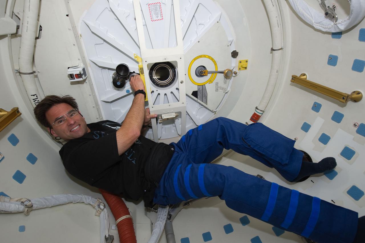 S134-E-007289 (18 May 2011) --- NASA astronaut Greg Chamitoff, STS-134 mission specialist, prepares to open the hatch that will lead the space shuttle Endeavour crew into the International Space Station. The two spacecraft docked at 6:14 a.m. (EDT) and the Endeavour crew entered the orbital outpost at 7:38 a.m. May 18, 2011. Photo credit: NASA