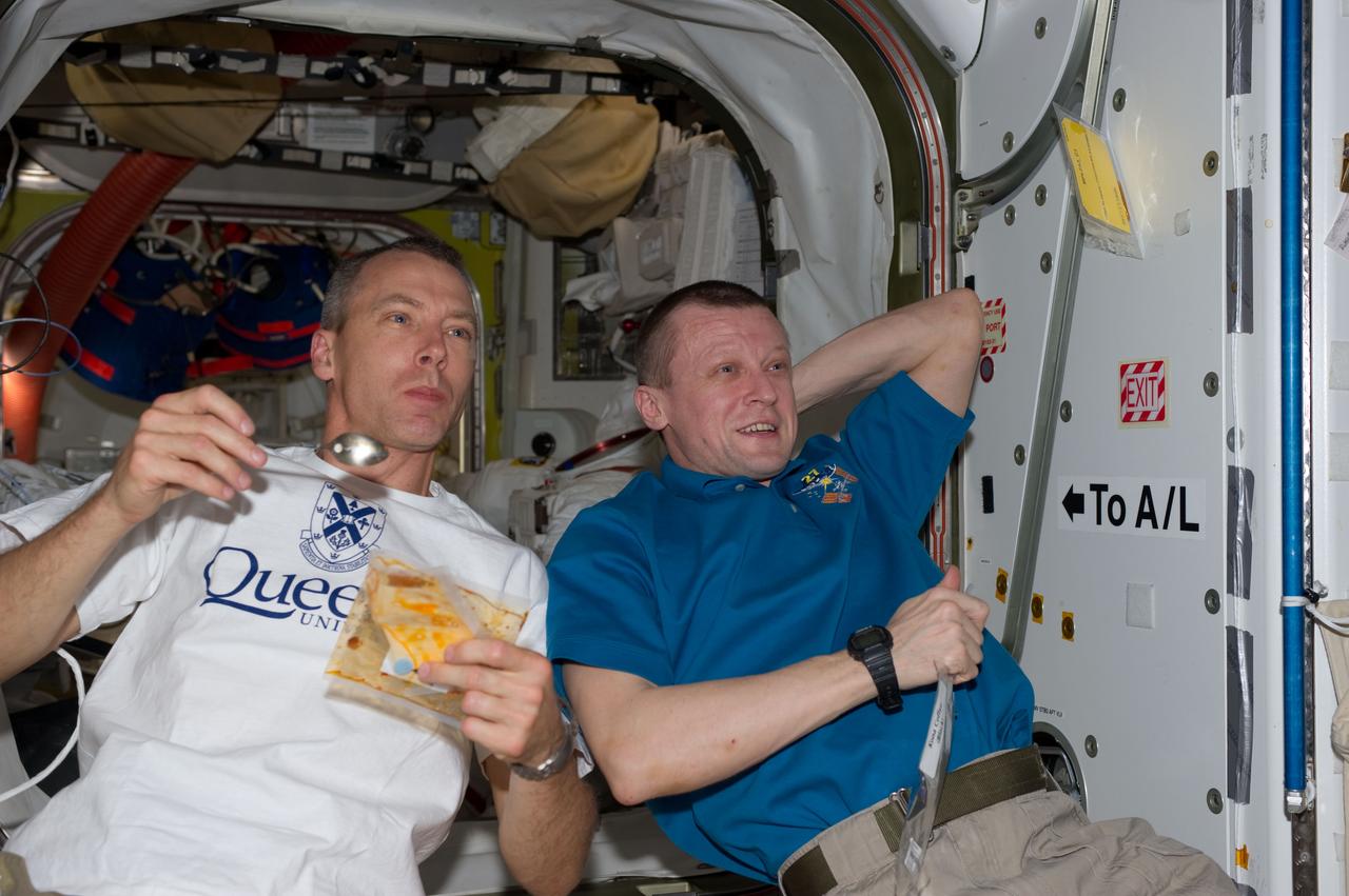 S134-E-008391(21 May 2011) --- Onboard the International Space Station, this snack time snap shot catches two of the twelve joint Expedition 27/STS-134 crew members during a break in a very busy schedule. NASA astronaut Andrew Feustel, STS-134 mission specialist, is at left, and he is joined Russian cosmonaut Dmitry Kondratyev, Expedition 27 commander. Photo credit: NASA