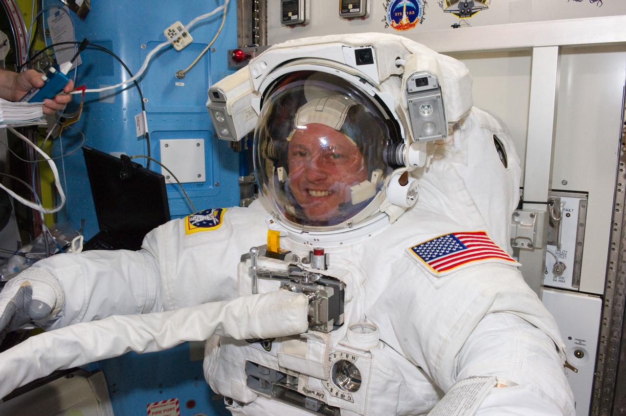 S134-E-008467 (22 May 2011) --- Wearing an Extravehicular Mobility Unit spacesuit, NASA astronauts Michael Fincke (left) and Andrew Feustel (out of frame), both STS-134 mission specialists, get prepared for the mission's second spacewalk onboard the International Space Station (ISS). Once outside the orbiting complex, Fincke and Feustel coordinated their shared activity with NASA astronaut Greg Chamitoff (out of frame), who stayed in communication with the pair and with Mission Control Center in Houston from the shirt sleeve environment inside the ISS. Photo credit: NASA