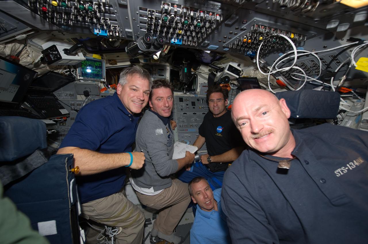 S134-E-010911 (30 May 2011) --- STS-134 crew members are busy on the aft flight deck of space shuttle Endeavour during undocking and fly-around operations with the International Space Station on flight day 15. Pictured are NASA astronauts Mark Kelly (right), commander; and Greg H. Johnson (left), pilot; along with European Space Agency astronaut Roberto Vittori (second left), NASA astronauts Andrew Feustel (bottom) and Greg Chamitoff, all mission specialists. Photo credit: NASA