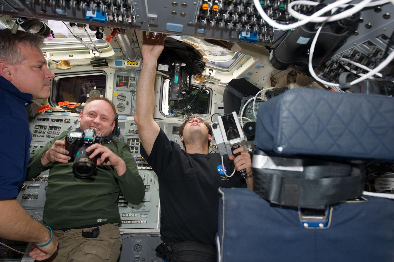 S134-E-010933 (30 May 2011) --- NASA astronauts Greg H. Johnson (left), STS-134 pilot; Michael Fincke (center) and Greg Chamitoff, both mission specialists, are busy on the aft flight deck of space shuttle Endeavour during undocking and fly-around operations with the International Space Station on flight day 15. Chamitoff is using a handheld laser ranging device -- designed to measure the range between two spacecraft -- through one of the overhead windows. Photo credit: NASA