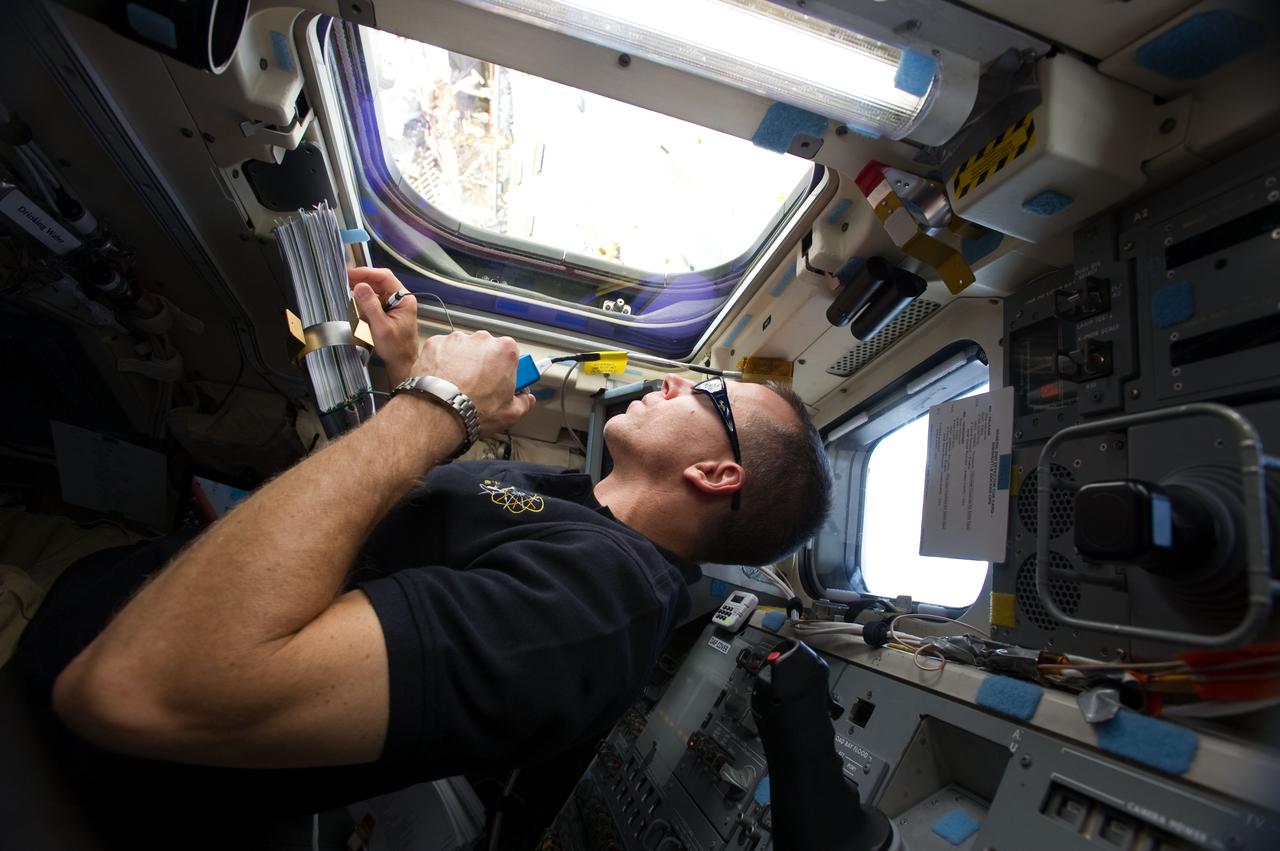 S134-E-011112 (27 May 2011) --- NASA astronaut Andrew Feustel, STS-134 mission specialist, uses a communication system while looking through an overhead aft flight deck window of space shuttle Endeavour while docked with the International Space Station on flight day 12. Photo credit: NASA