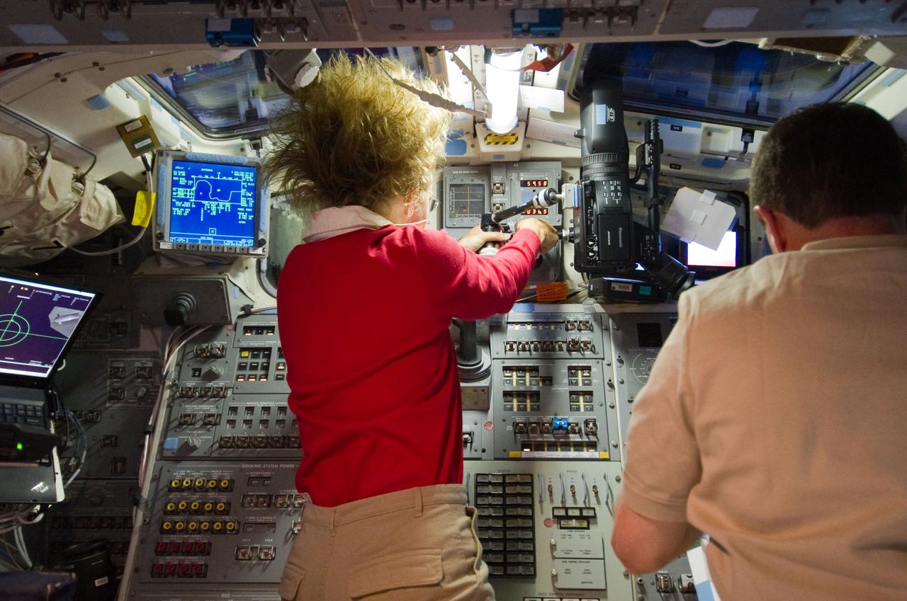 S135-E-007118 (10 July 2011) ? NASA astronaut Sandy Magnus, STS-135 mission specialist, is pictured at controls on the flight deck of the space shuttle Atlantis during rendezvous and docking operations with the International Space Station. NASA astronaut Rex Walheim, mission specialist, is at right. Photo credit: NASA