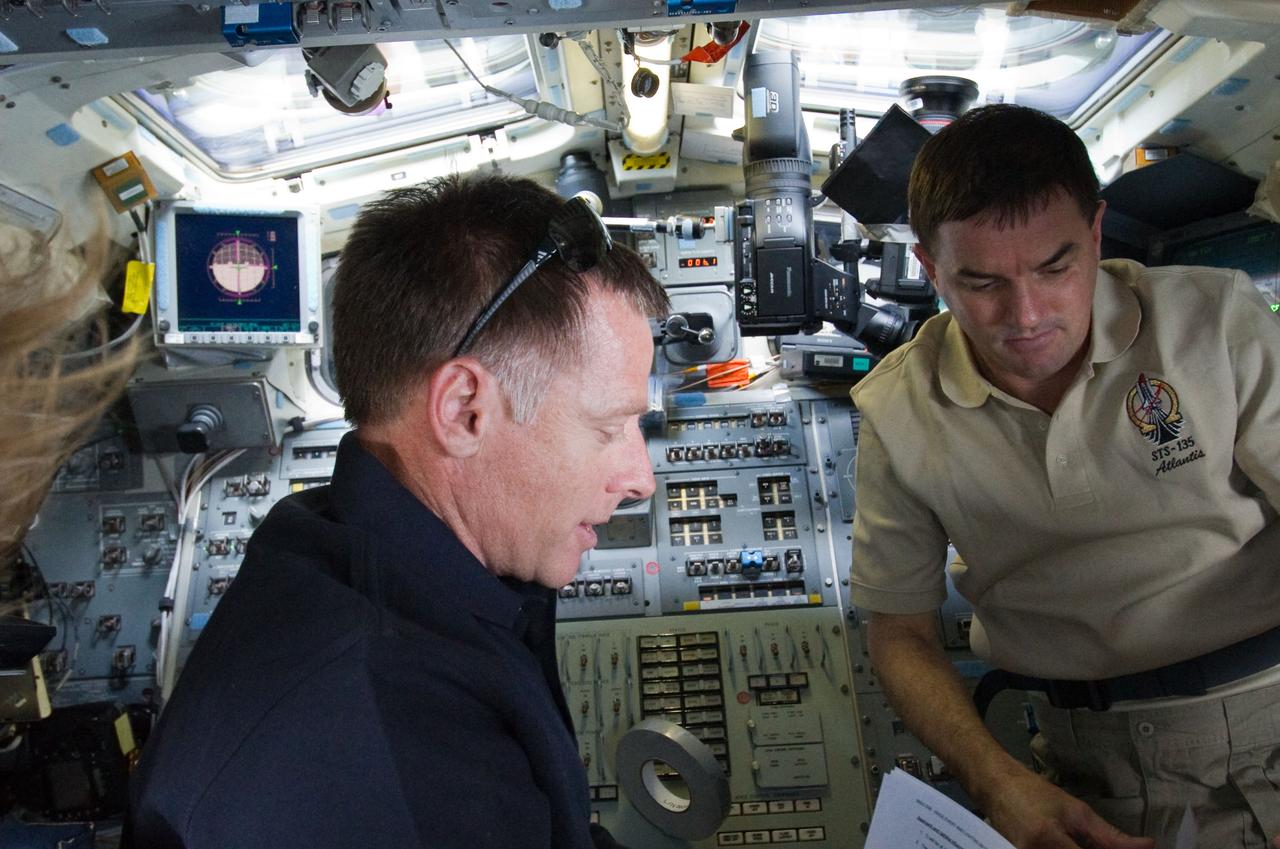 S135-E-007155 (10 July 2011) –-- NASA astronauts Chris Ferguson (left), STS-135 commander, and Rex Walheim, mission specialist, are pictured on the aft flight deck of the space shuttle Atlantis prior to docking with the International Space Station during the mission’s third day in space. Photo credit: NASA