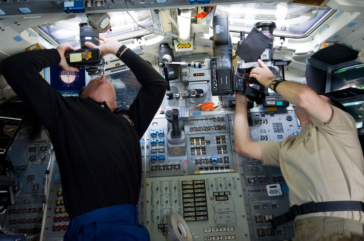 S135-E-007160 (10 July 2011) –-- NASA astronauts Chris Ferguson (left), STS-135 commander, and Rex Walheim, mission specialist, are pictured on the aft flight deck of the space shuttle Atlantis prior to docking with the International Space Station during the mission’s third day in space. Photo credit: NASA