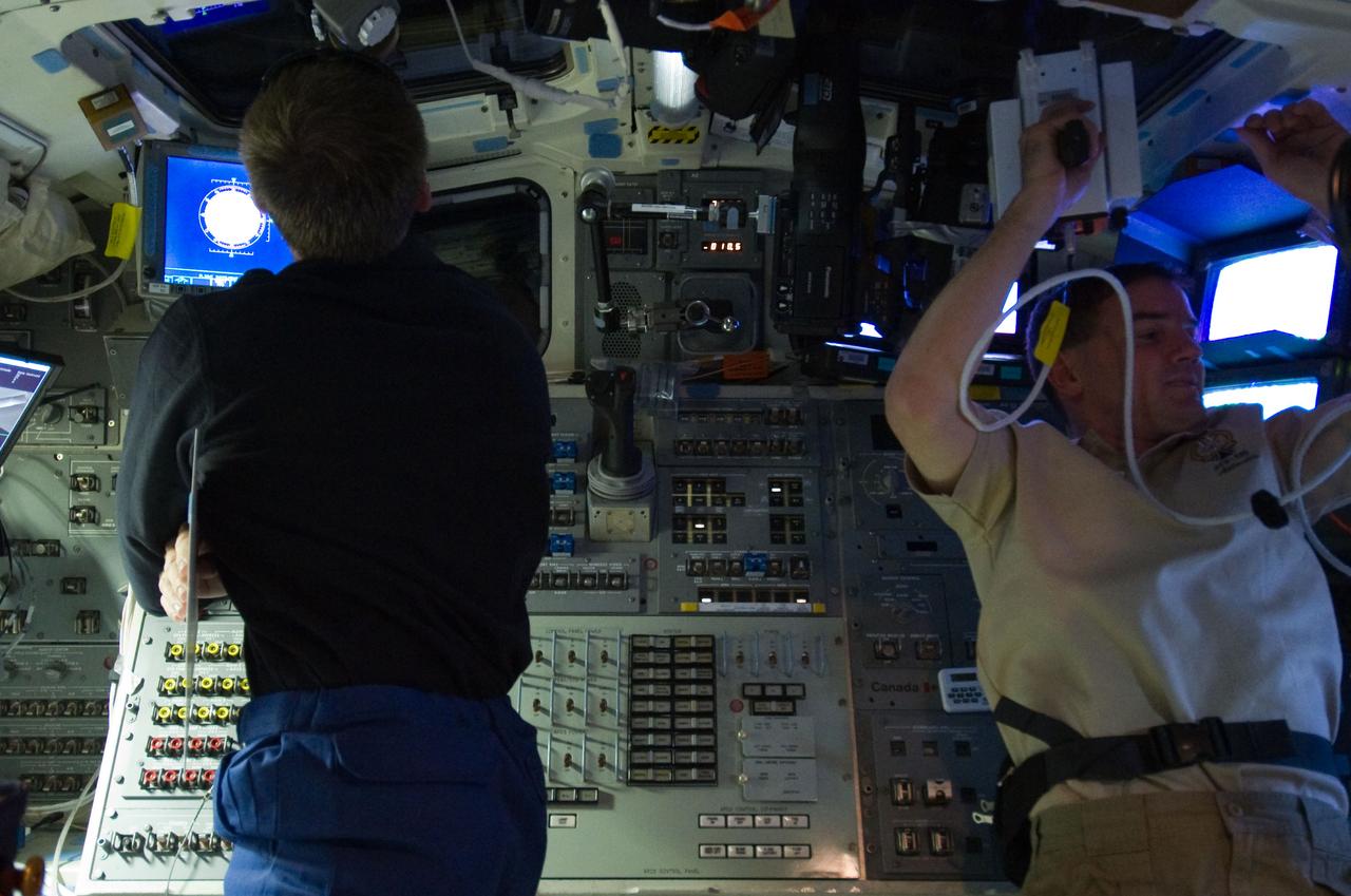 S135-E-007204 (10 July 2011) –-- NASA astronauts Chris Ferguson (left), STS-135 commander, and Rex Walheim, mission specialist, are pictured on the aft flight deck of the space shuttle Atlantis prior to docking with the International Space Station during the mission’s third day in space. Walheim uses a range finder in support of the rendezvous and docking operations. Photo credit: NASA