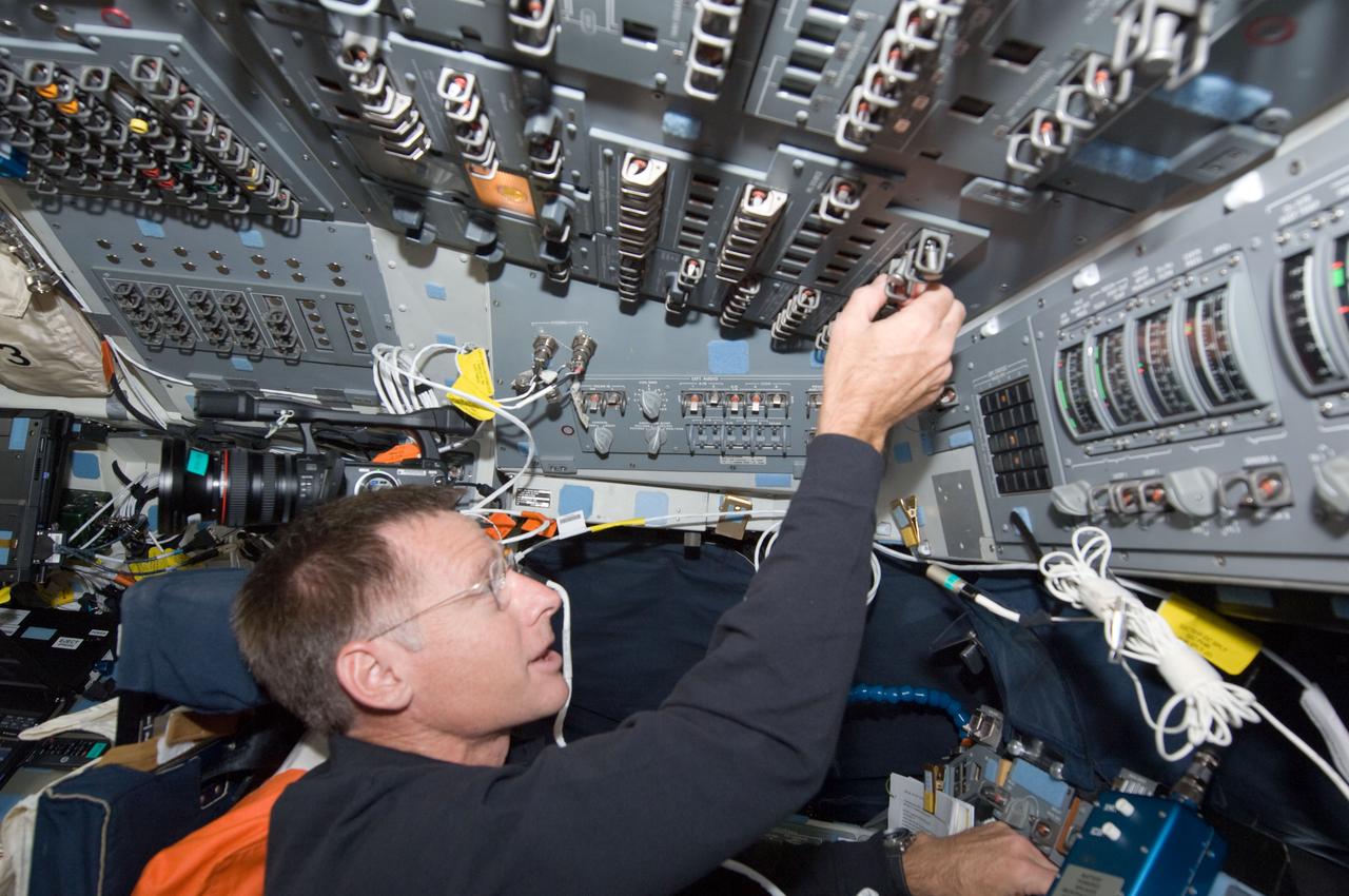 S135-E-007350 (11 July 2011) ---  NASA astronaut Chris Ferguson, STS-135 mission commander, toggles switches on the overhead panel of the forward flight deck of the space shuttle Atlantis. The image was recorded during the mission's fourth day of activities in Earth orbit and second day while being docked with the International Space Station. Photo credit: NASA