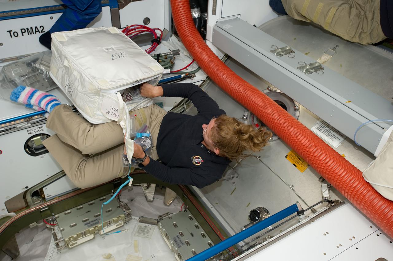 S135-E-007401 (11 July 2011) ---  Toting a cargo transfer bag filled with supplies that was carried aboard Raffaello in Atlantis' cargo bay, NASA astronaut Sandy Magnus participates in a very busy move operation on the fourth day in space for the STS-135 crew. She is in Node 2 or Harmony, near the PMA-2 passageway, on the International Space Station.  She is sporting the striped socks that she rediscovered on the station which had remained there since her long duration stay on the orbital outpost a few years ago. Photo credit: NASA