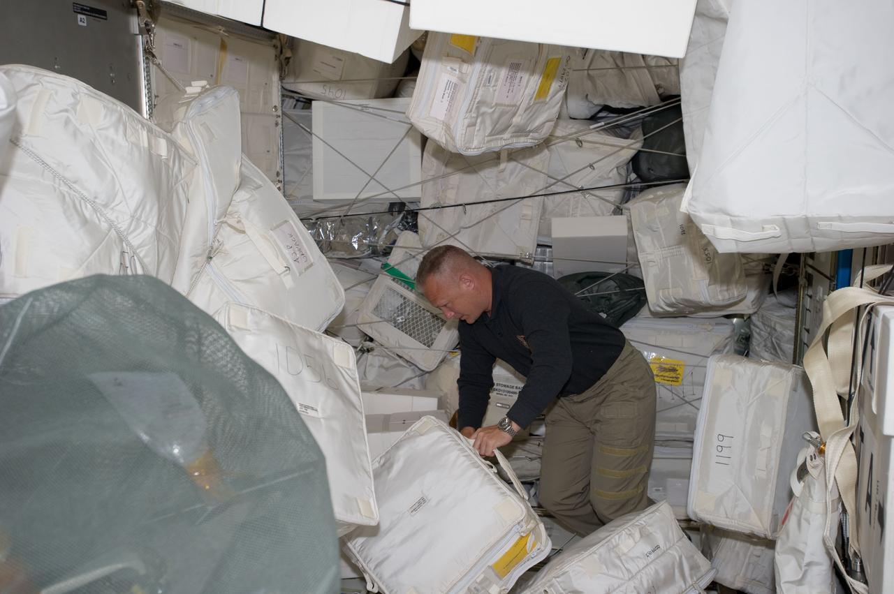 S135-E-007437 (11 July 2011) --- NASA astronaut Doug Hurley, STS-135 pilot, moves around supplies and equipment in the Leonardo Permanent Multipurpose Module (PMM) during the fourth day of flight for Atlantis' four person crew. This module is a component that joined the International Space Station complex after it was flown into space aboard the space shuttle Discovery on STS-133. Photo credit: NASA